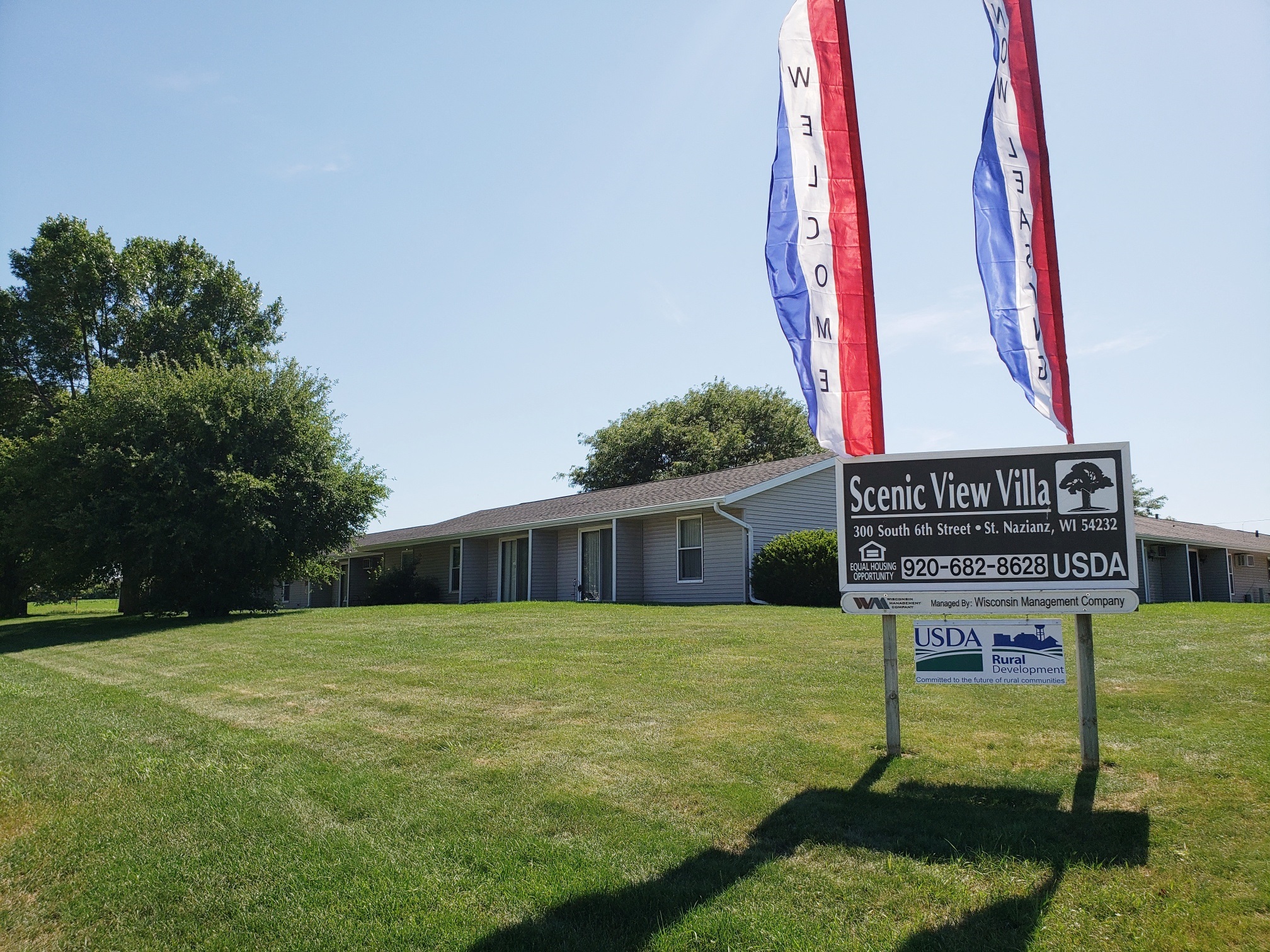 a yard with a sign in front of a house