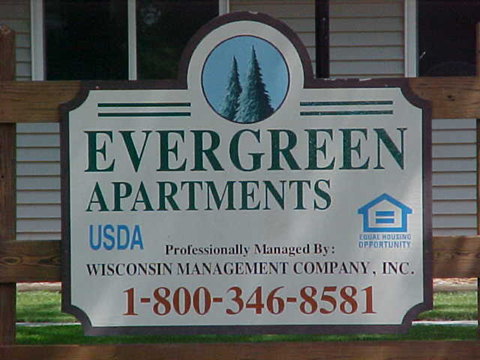 a sign for evergreen apartments in front of a building