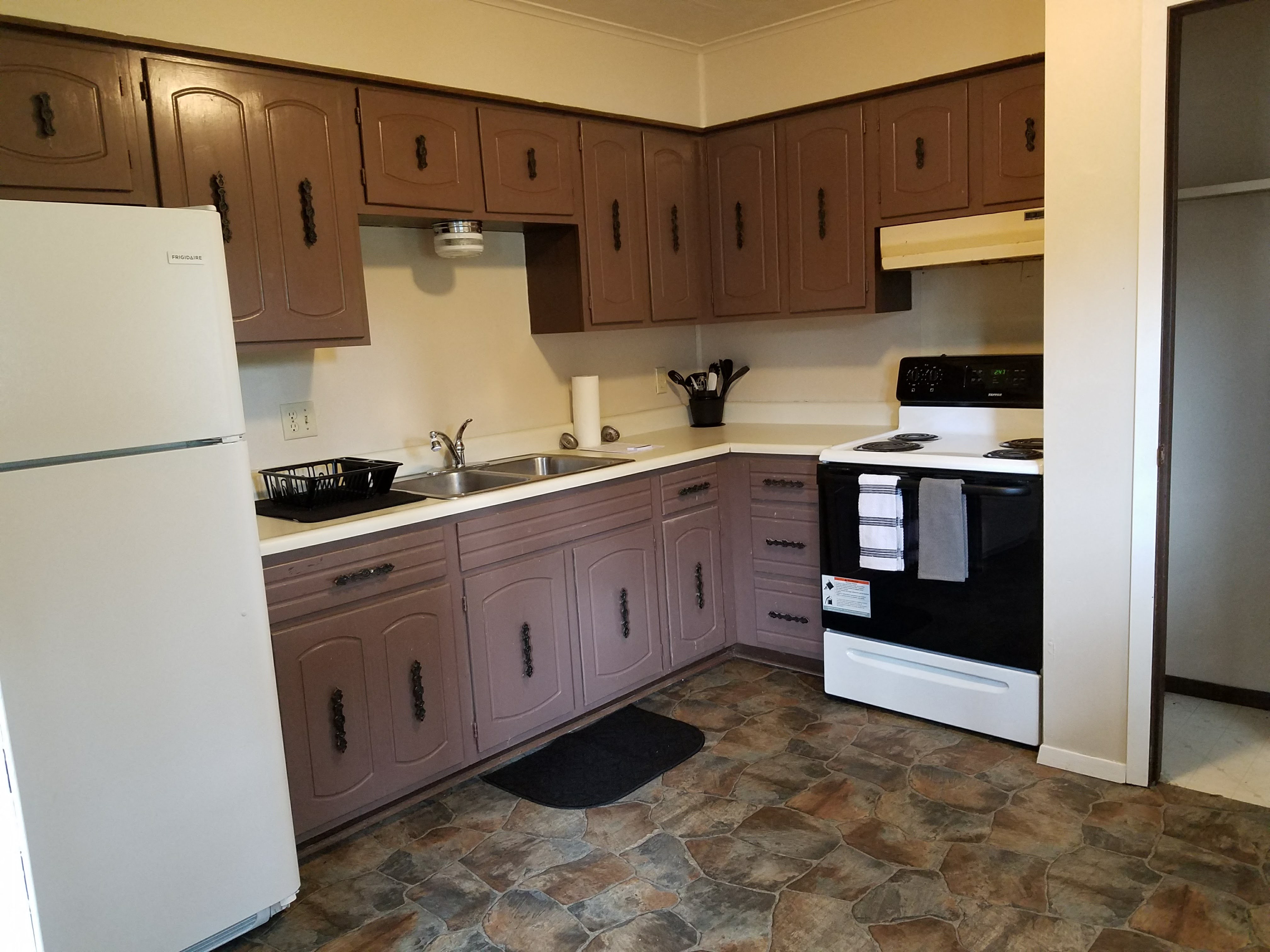 a kitchen with white appliances and wooden cabinets
