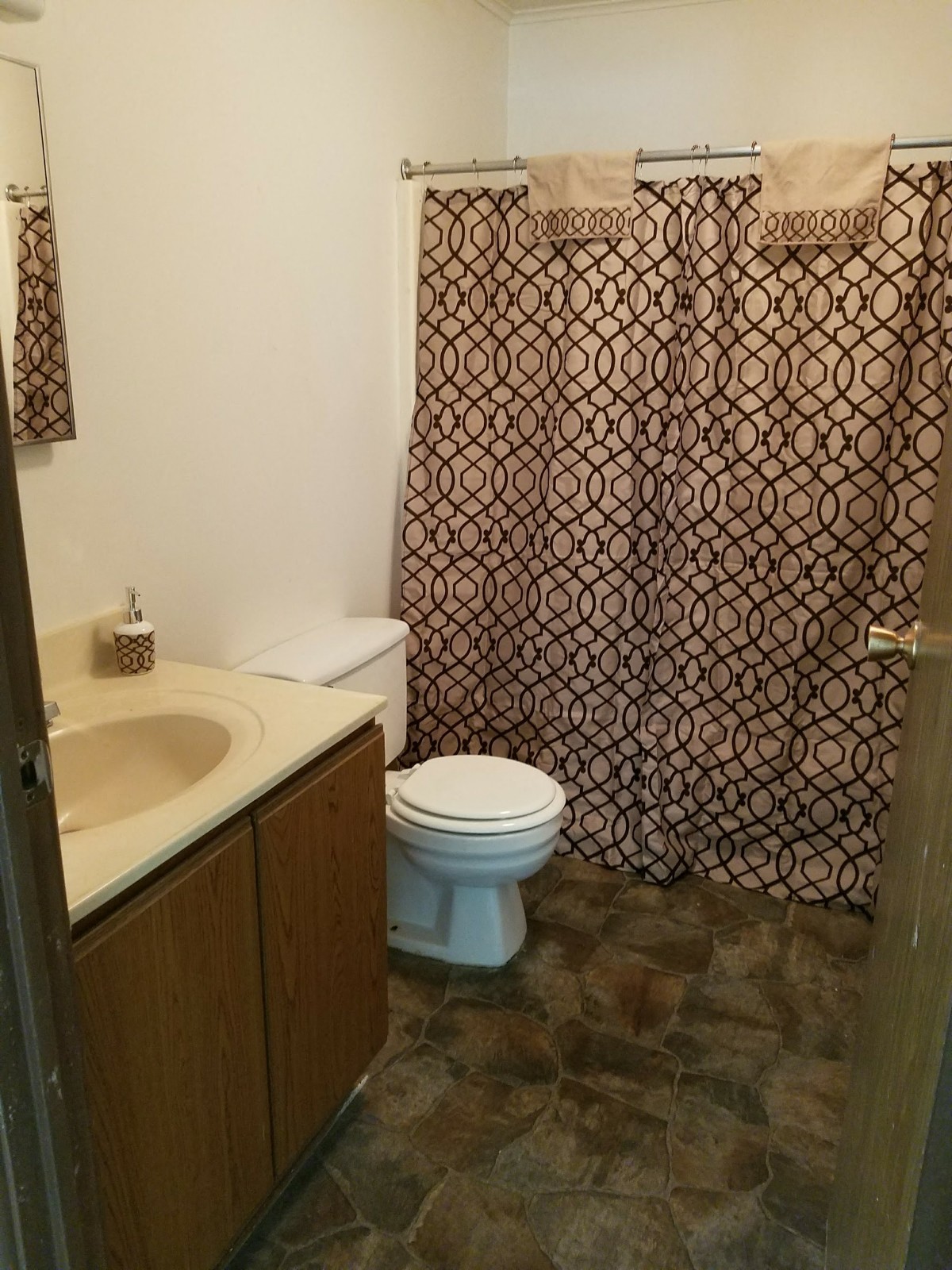a bathroom with a toilet and a sink and a shower curtain