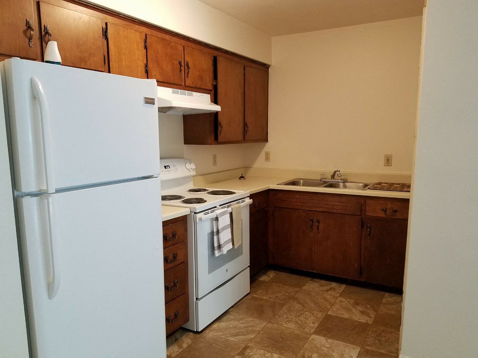 a kitchen with white appliances and wooden cabinets