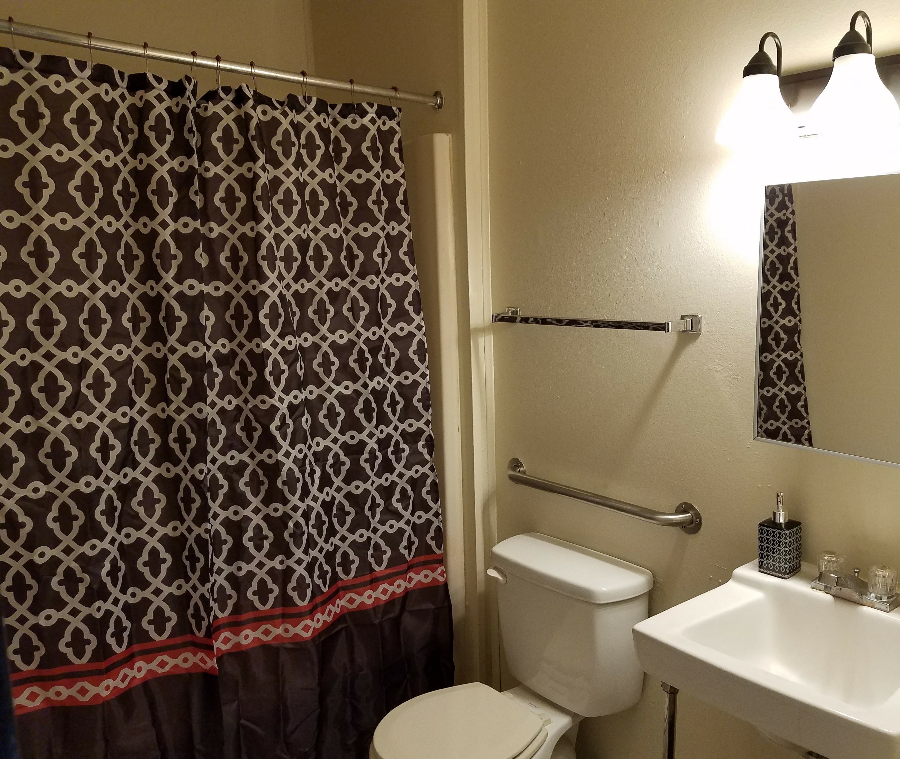 a bathroom with a shower and a toilet and a sink