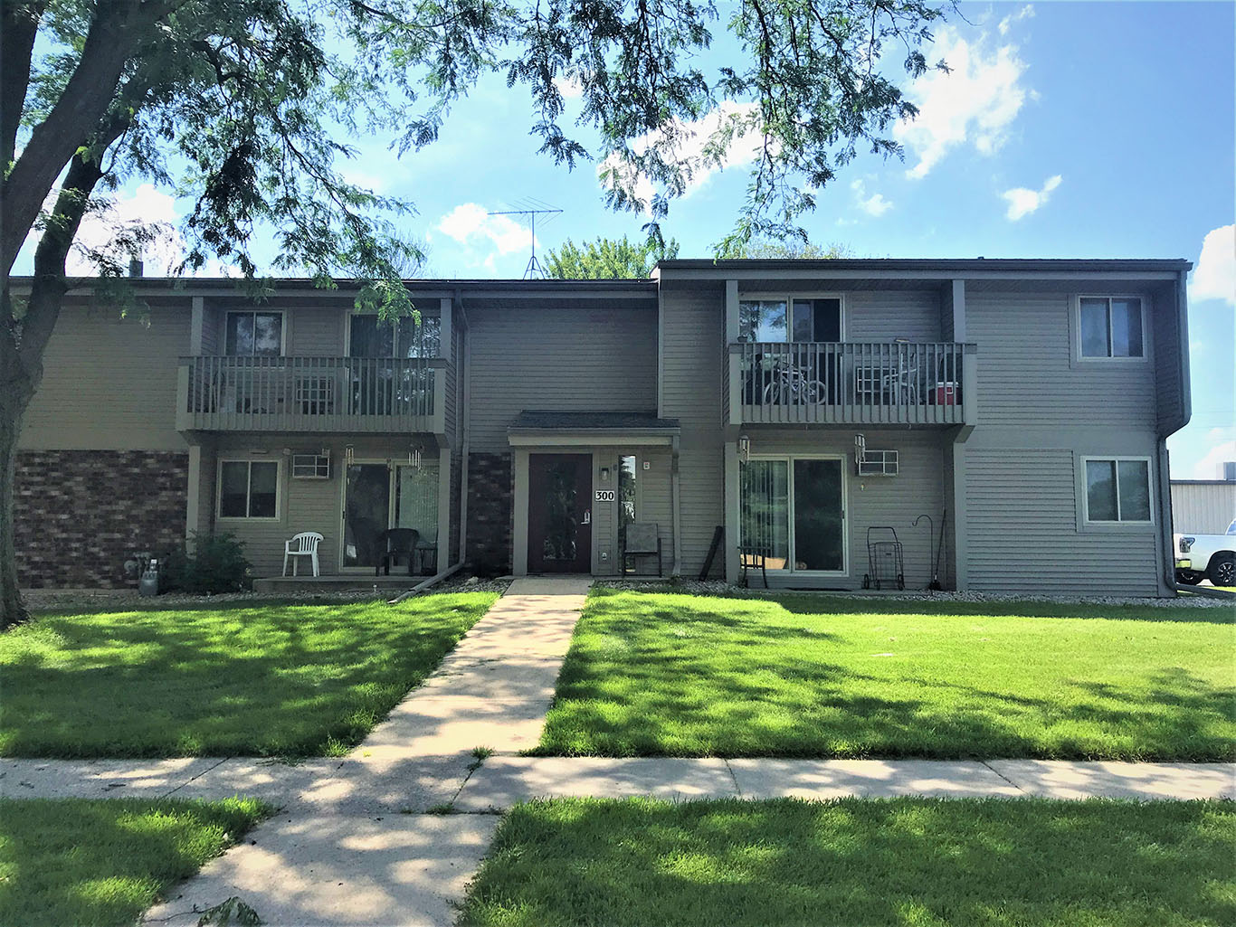 A sunny day at the apartment complex with green lawns and trees.