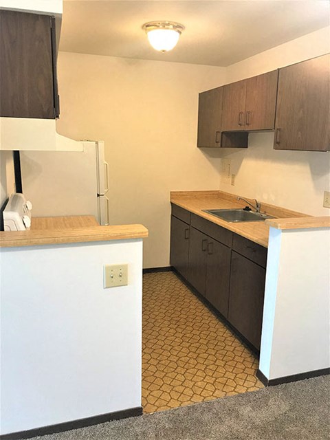 A kitchen with brown cabinets and a white counter.