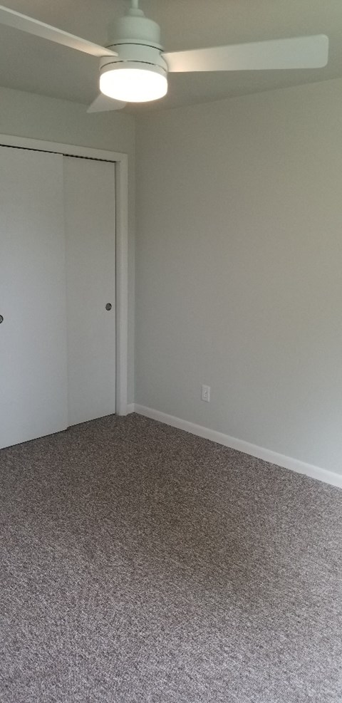 an empty living room with a carpeted floor and a door