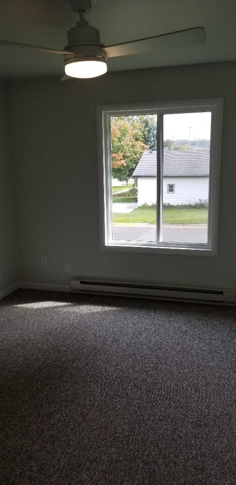 an empty room with a window and a ceiling light