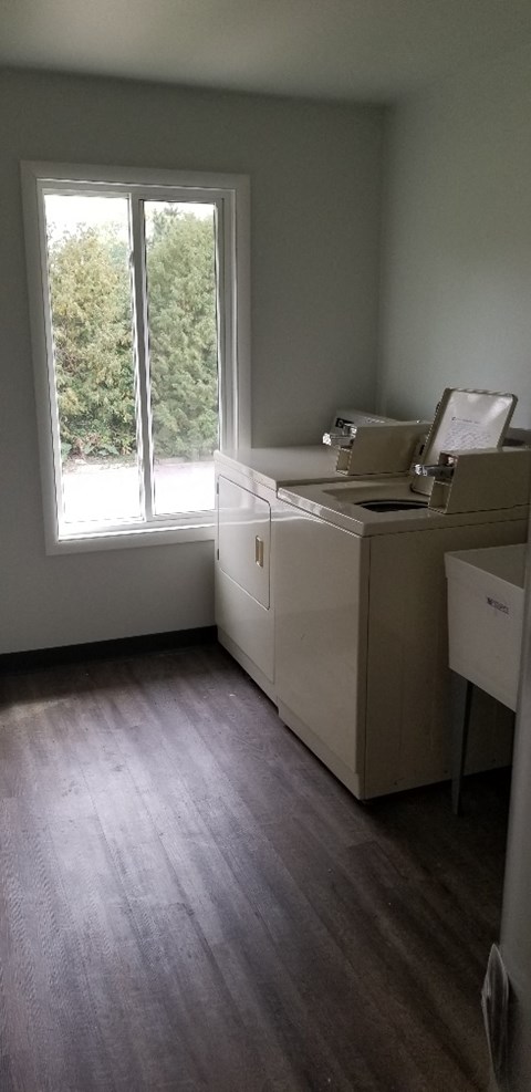 an empty room with a window and a washer and dryer
