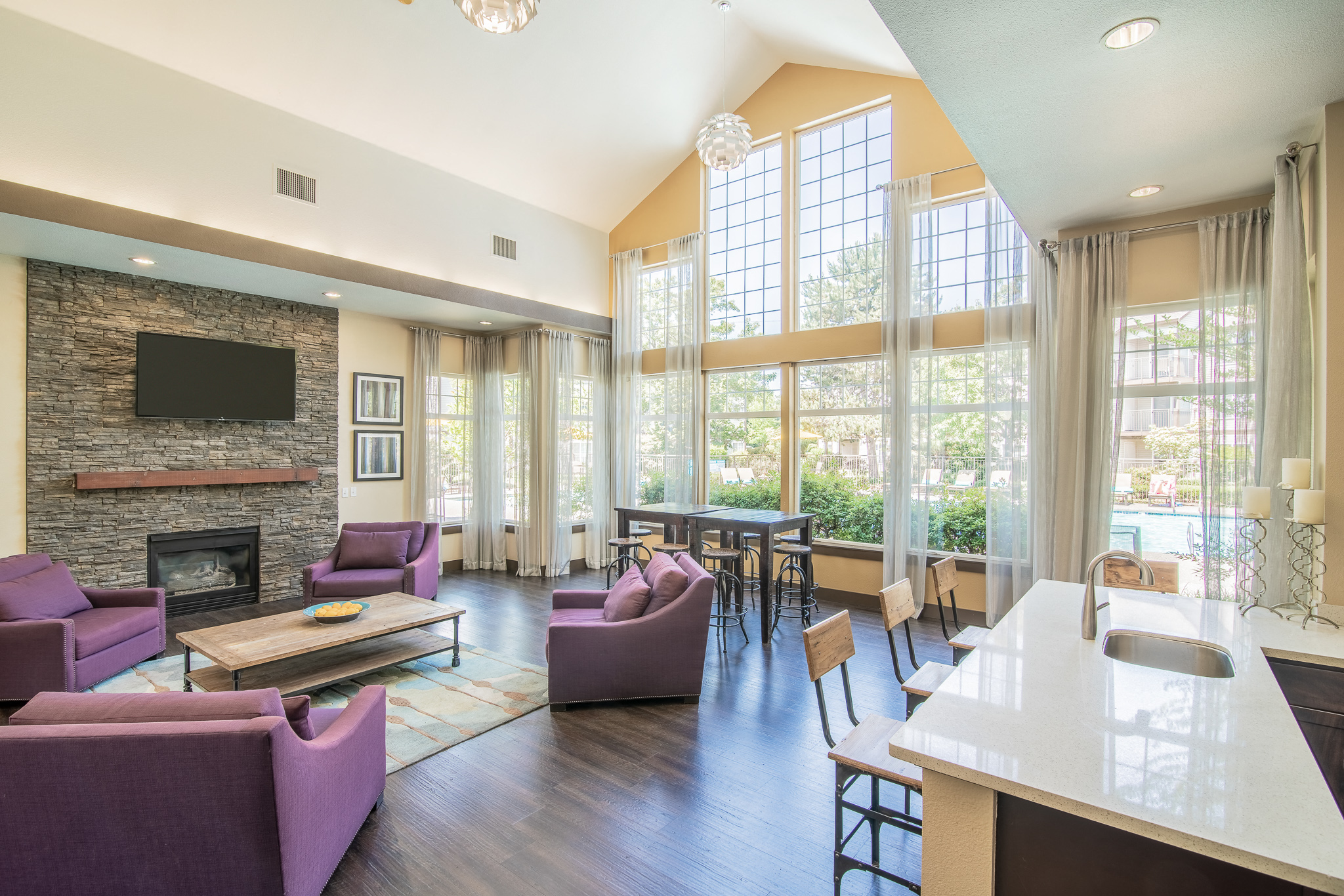 a living room with couches and a table with chairs and a fireplace