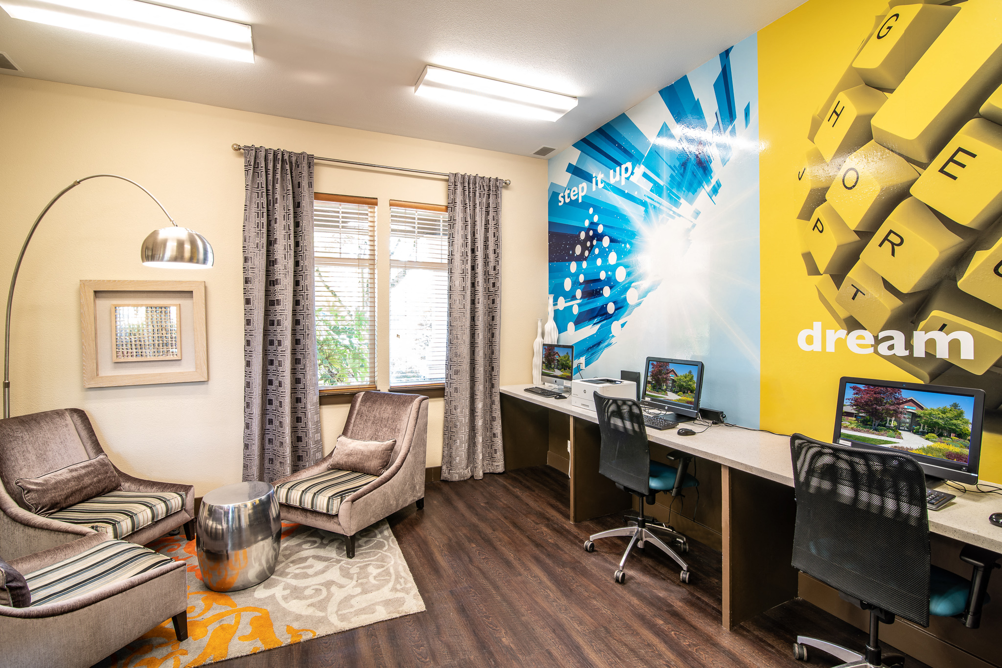 a room with two chairs and a desk and a mural on the wall