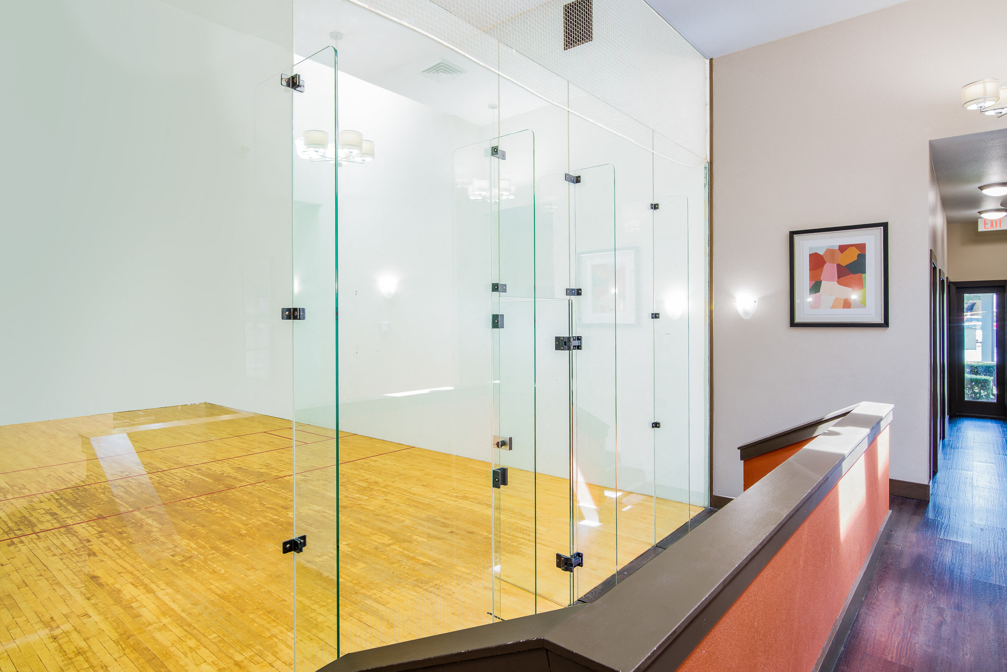 a glass walled dressing room with a wood floor and a mirror