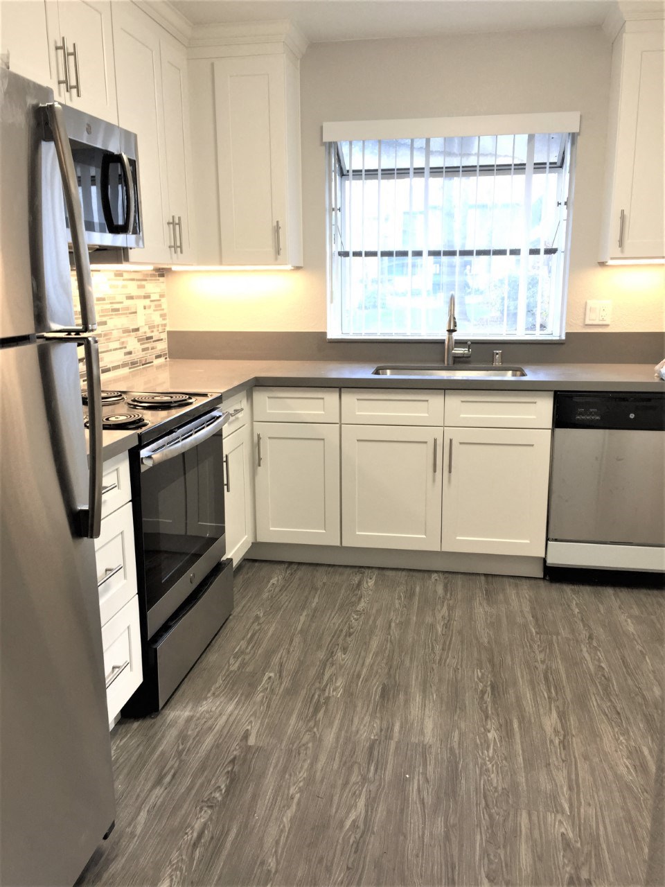 a kitchen with white cabinets and stainless steel appliances