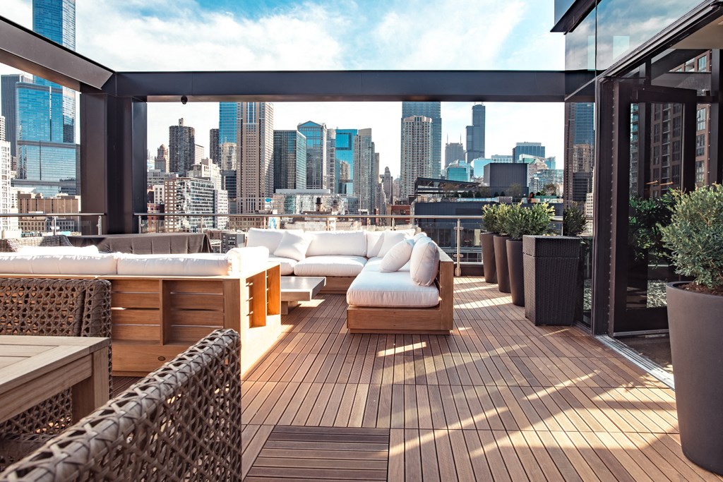 a balcony with a view of the city and a white couch