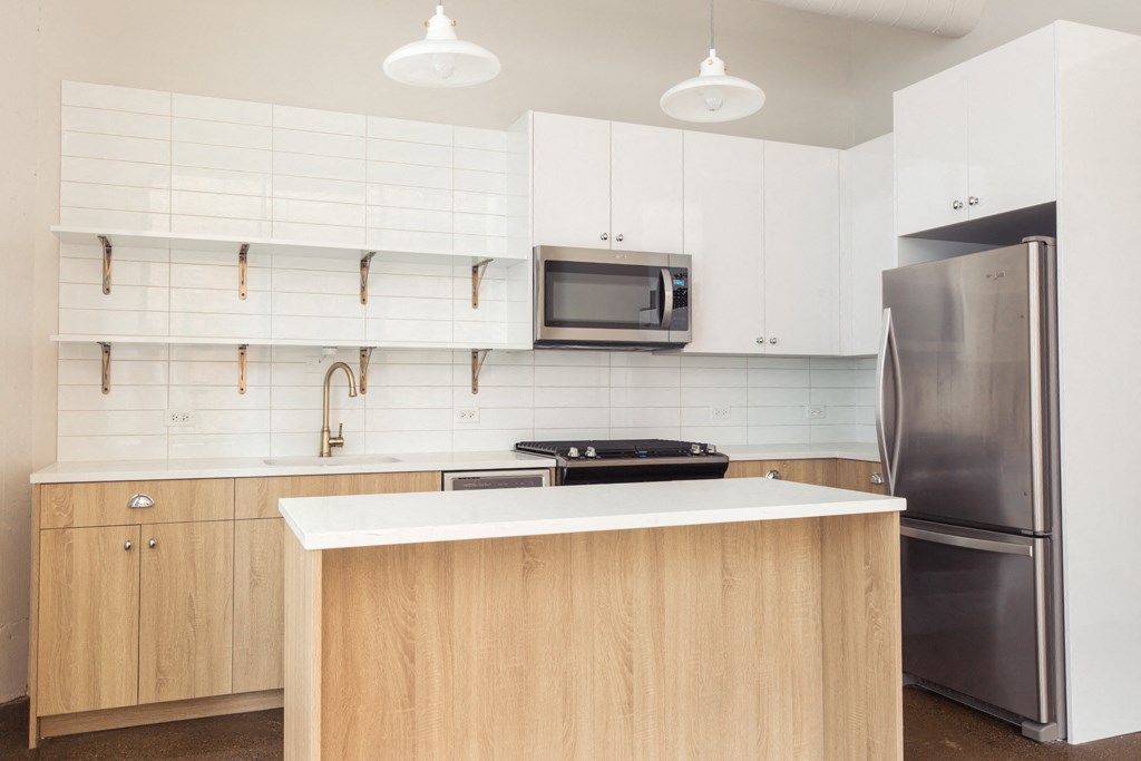a kitchen with white cabinets and a stainless steel refrigerator