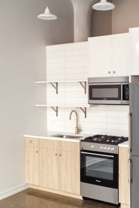 a kitchen with white cabinets and a stove and a microwave