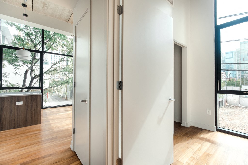a large white door in a room with a wood floor and a large window