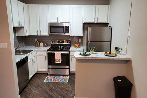 A kitchen with a stove top oven and a refrigerator.