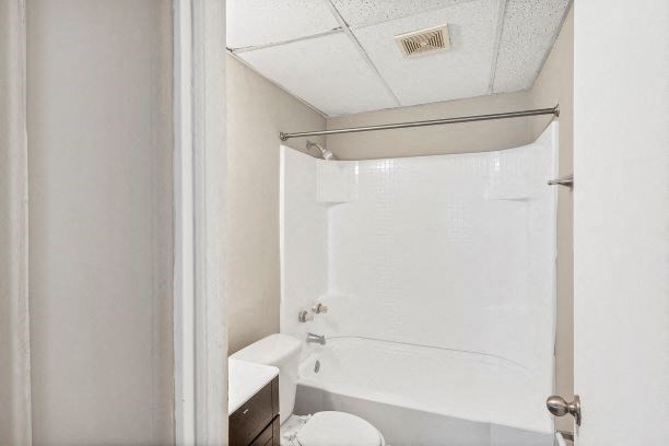 a white bathroom with a shower and a toilet