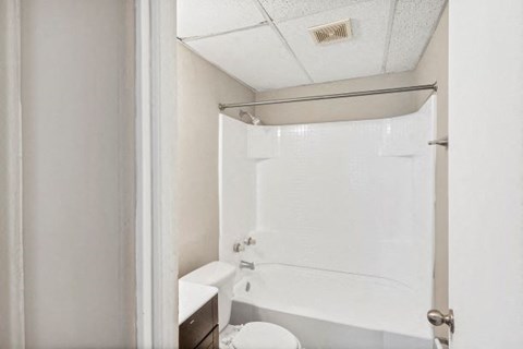 a white bathroom with a shower and a toilet