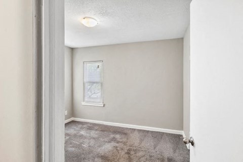 an empty room with an open door and a window