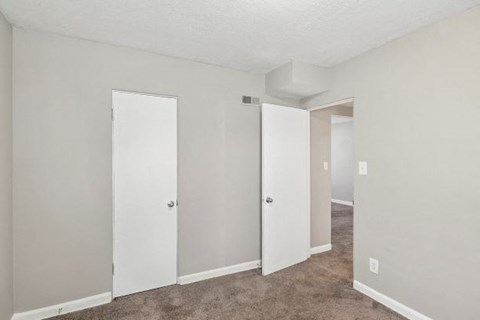 an empty room with white walls and doors