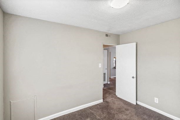 an empty living room with a door to a hallway