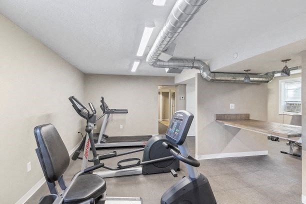 a gym with some exercise machines and a table