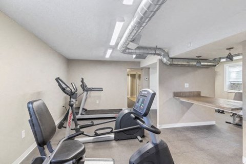 a gym with some exercise machines and a table