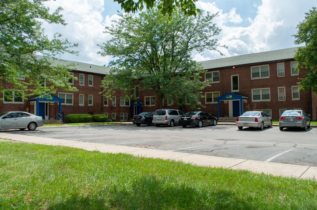 a large brick building with cars parked in a parking lot