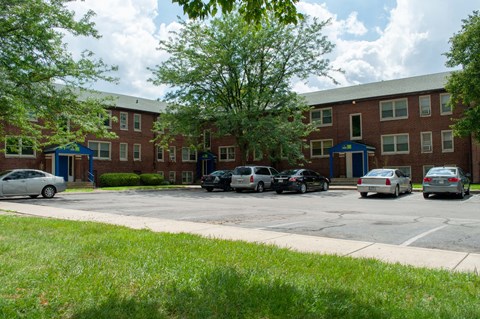 a large brick building with cars parked in a parking lot
