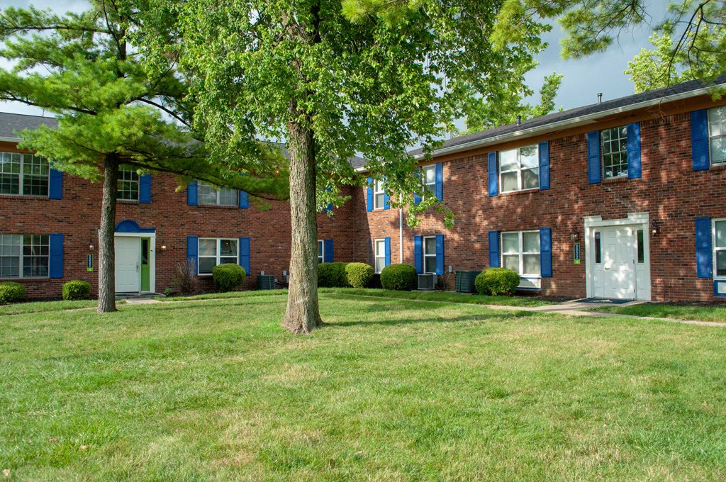 a large brick house with trees in front of it