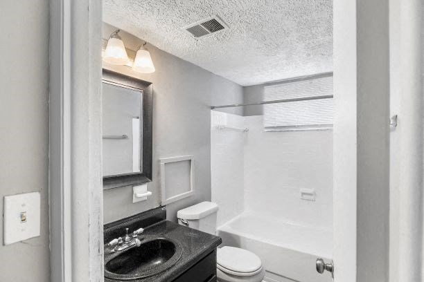 a white bathroom with a sink and a toilet