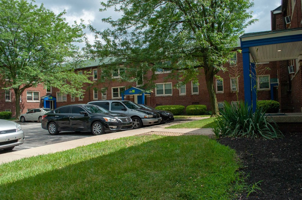 a parking lot with cars parked in front of a brick building