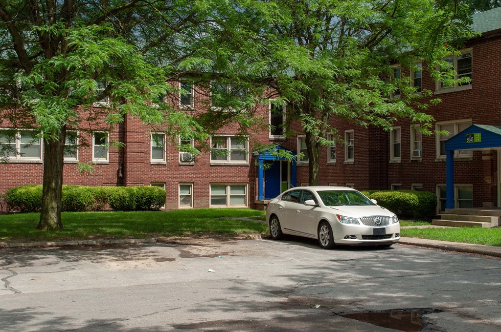 a car parked in front of a brick apartment building