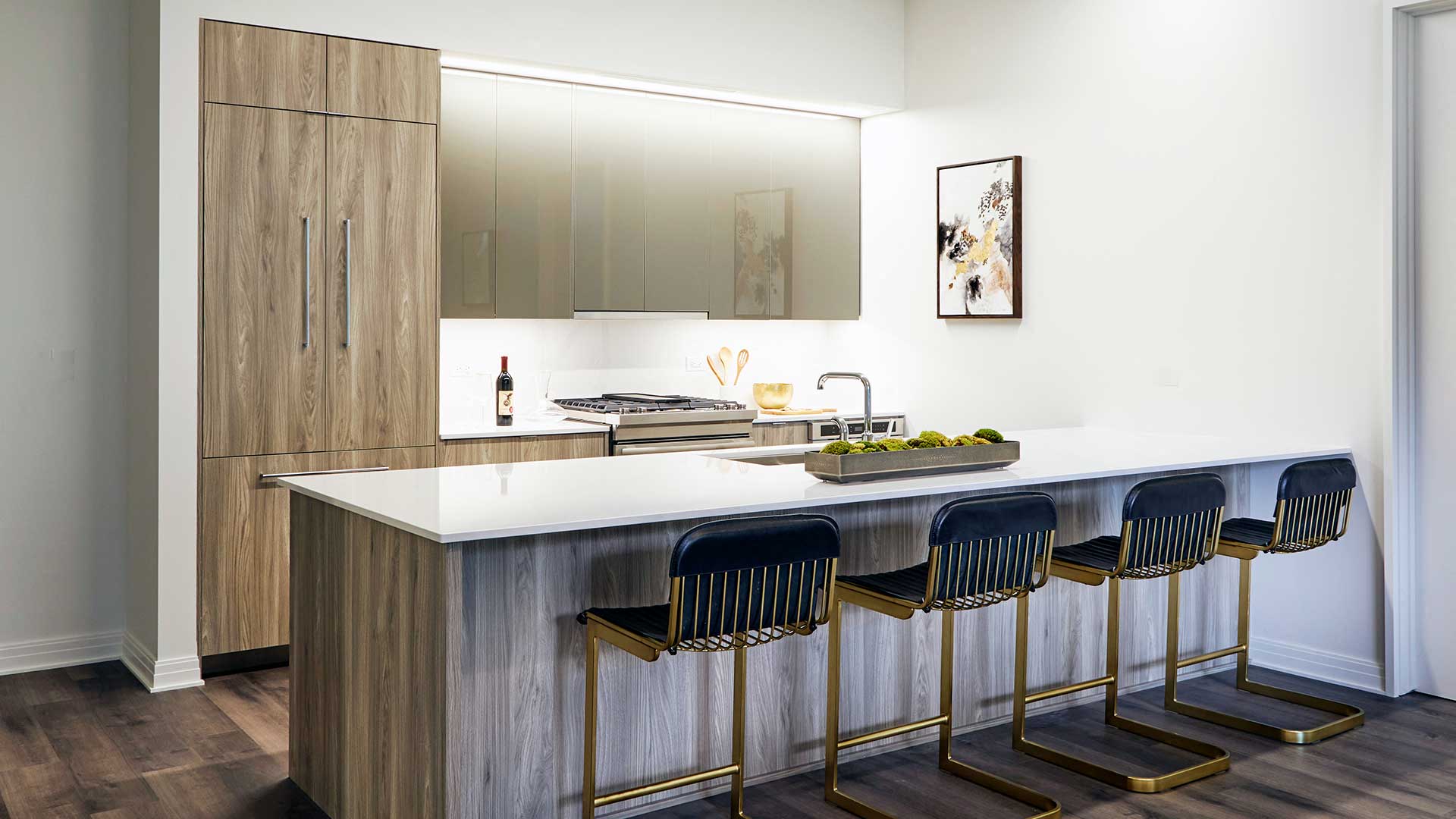 A kitchen counter with stools face the kitchen along the wall.