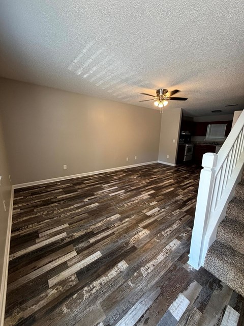 A room with a wooden floor and a ceiling fan.