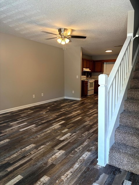 A room with a staircase and a ceiling fan.