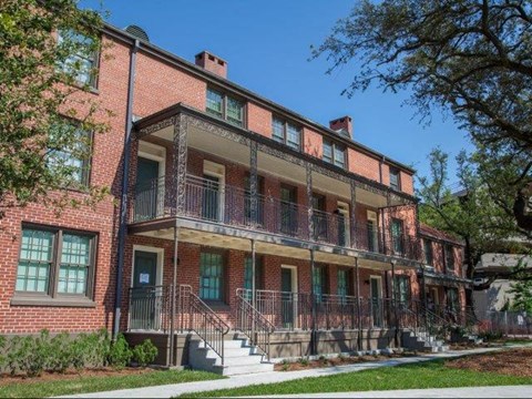 a red brick house with a porch and stairs