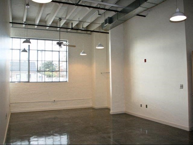 an empty room with white walls and a large window