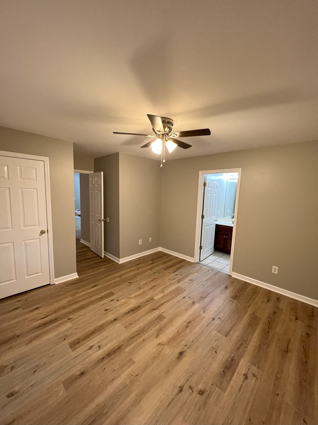 a living room with wood floors and a ceiling fan
