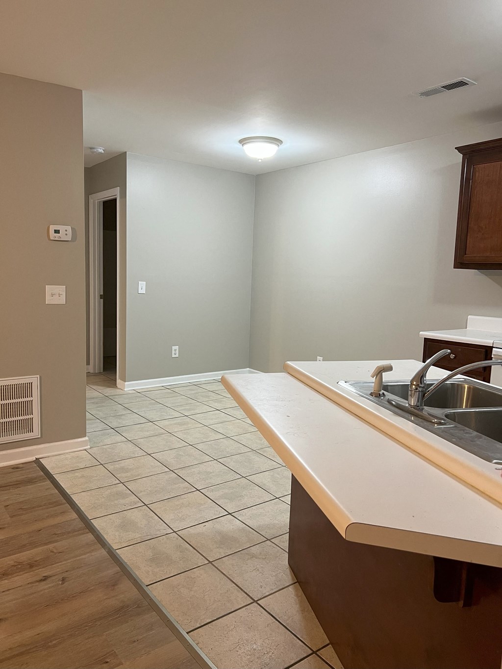 an empty kitchen and living room with a sink and a counter