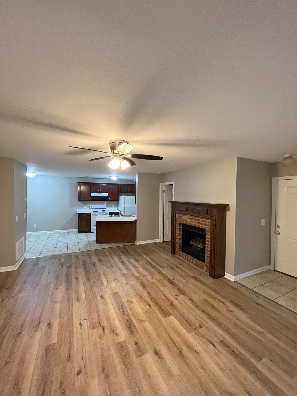 a living room with a fireplace and wooden floors