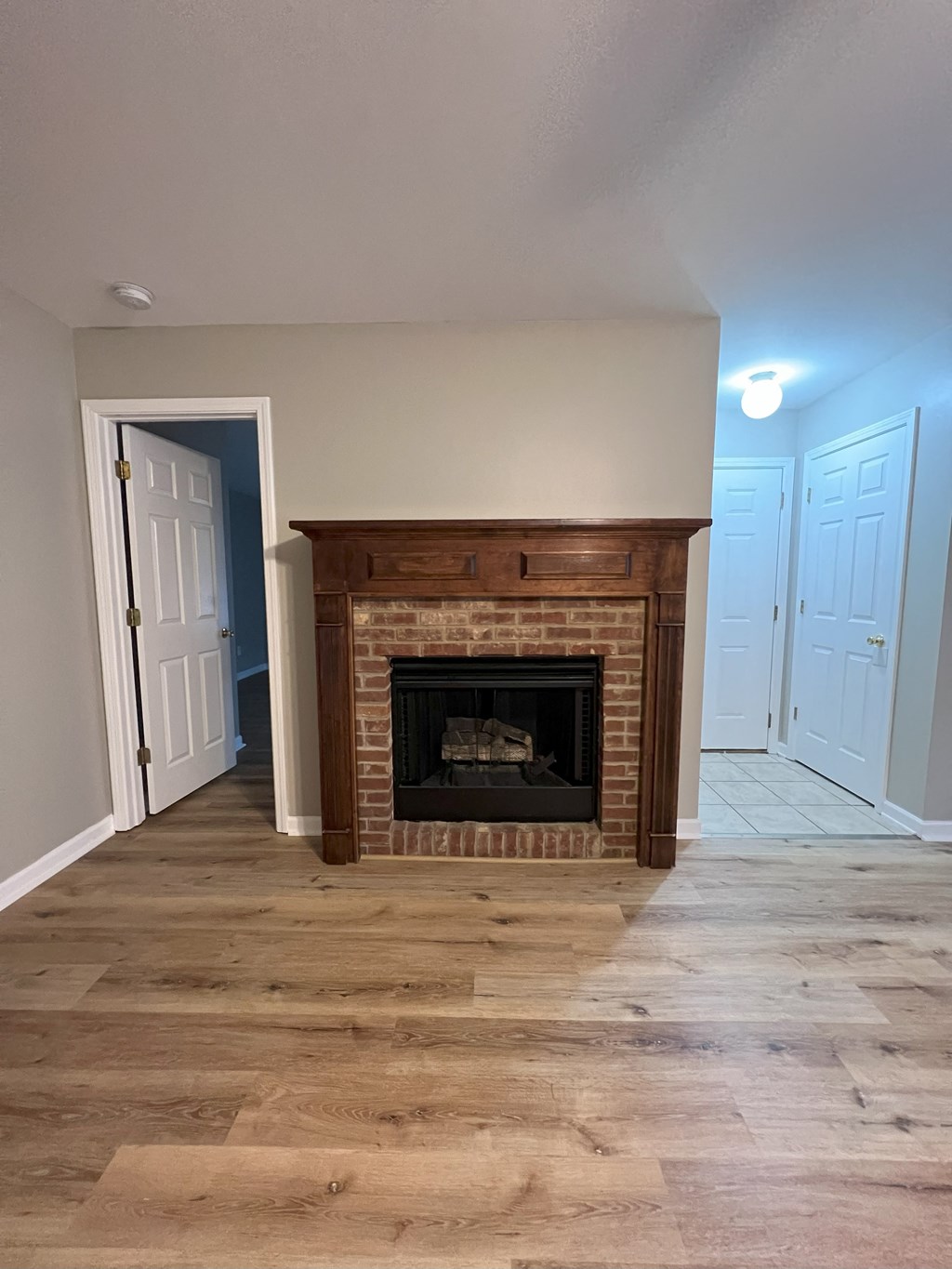 a living room with a brick fireplace and a wooden floor