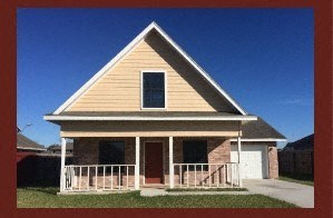 A small house with a porch and a garage door.