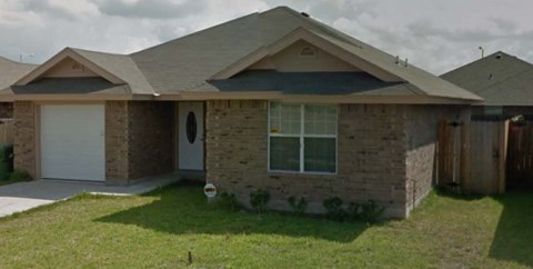 A house with a grey roof and a white garage door.