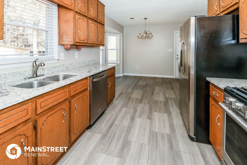 a kitchen with wooden cabinets and a stainless steel refrigerator