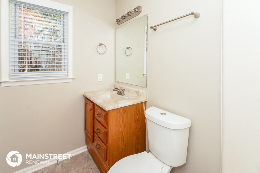 a bathroom with a toilet and a sink and a mirror