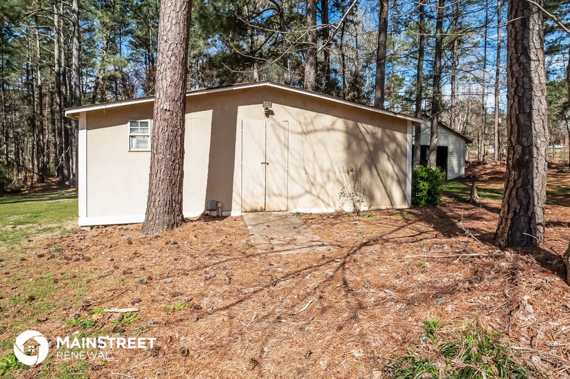 a small garage in the woods with trees