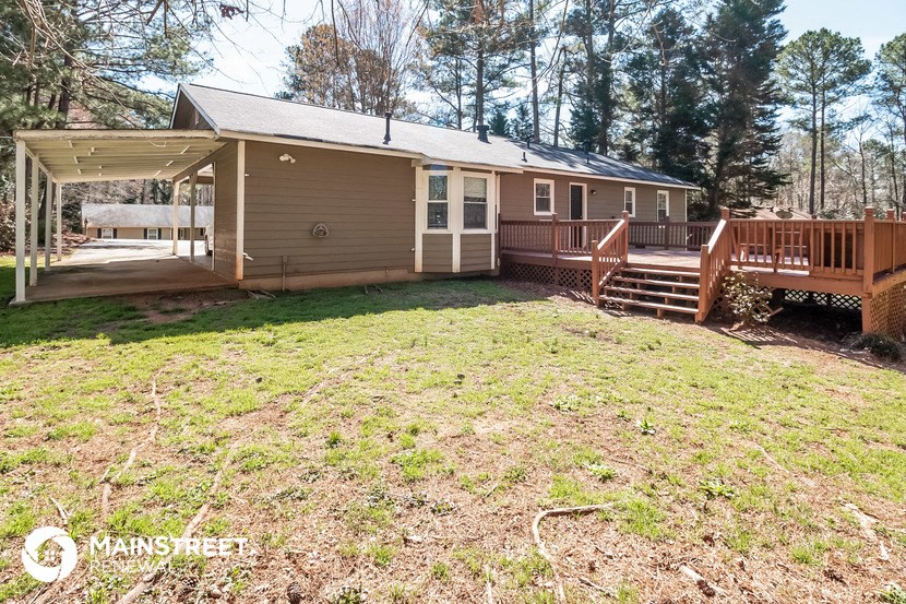 a small brown house with a yard and a porch