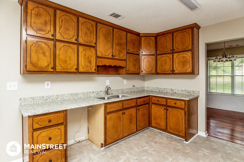 a kitchen with wooden cabinets and granite counter tops and a sink