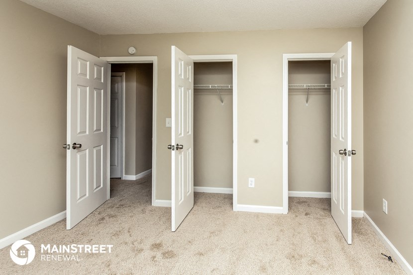 a bedroom with three closets and three doors